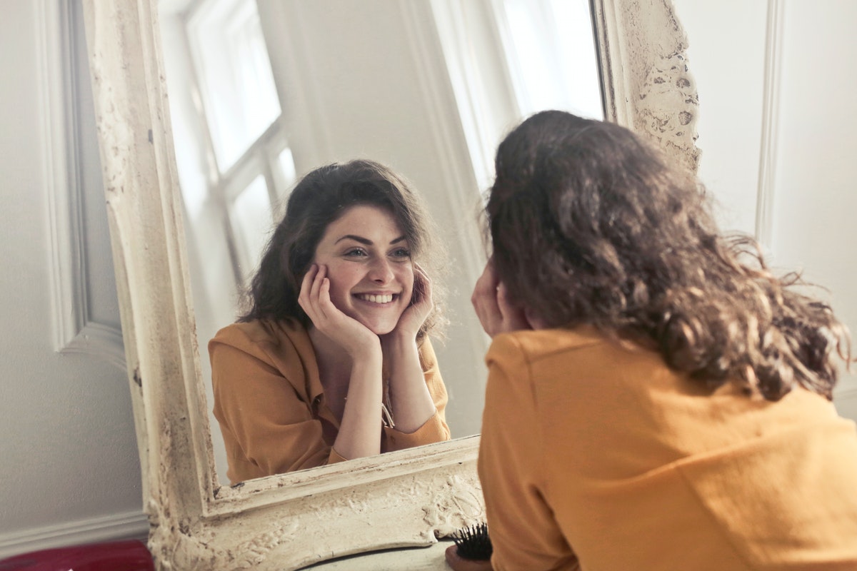 Egy nő a tükörben nézi magát. Spirulinával az egészséges és fiatalos bőrért